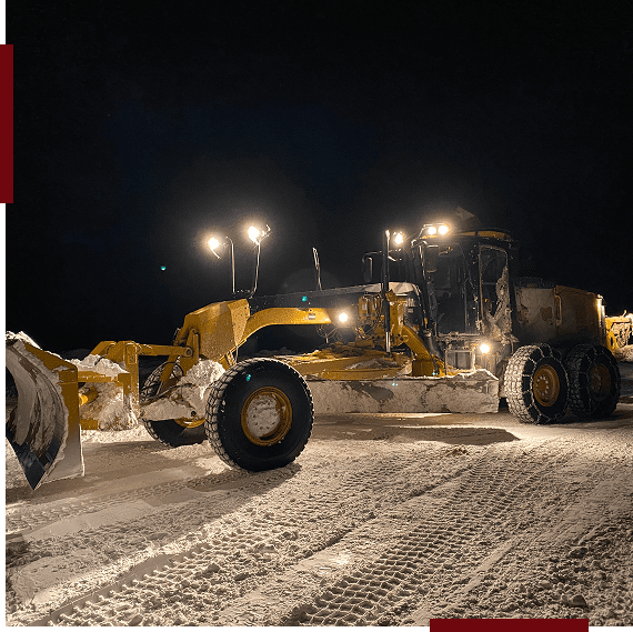 Snowplow clearing snow at night.